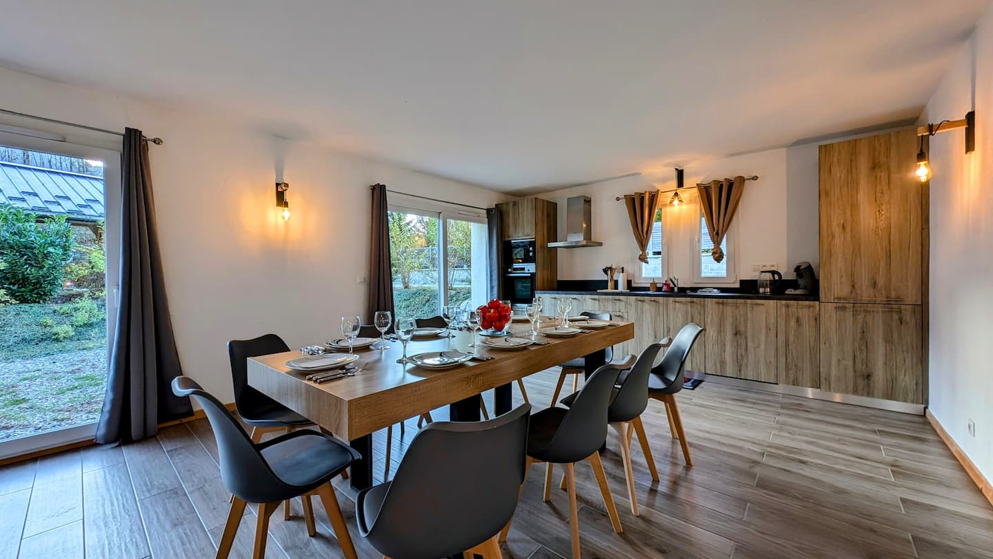 Long dining table beside the open kitchen and garden doors