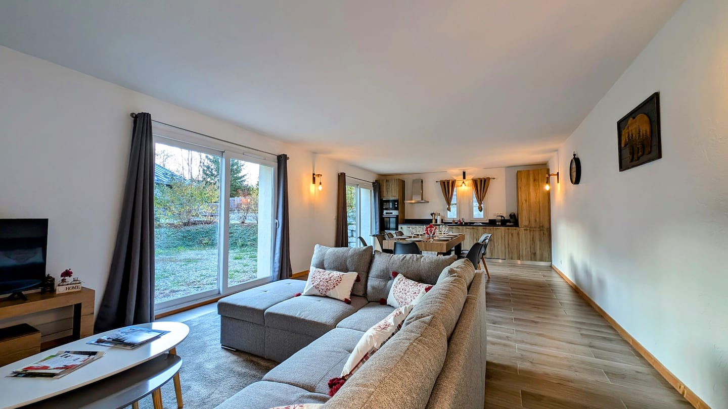 Bright living room with a large sofa and open kitchen beyond