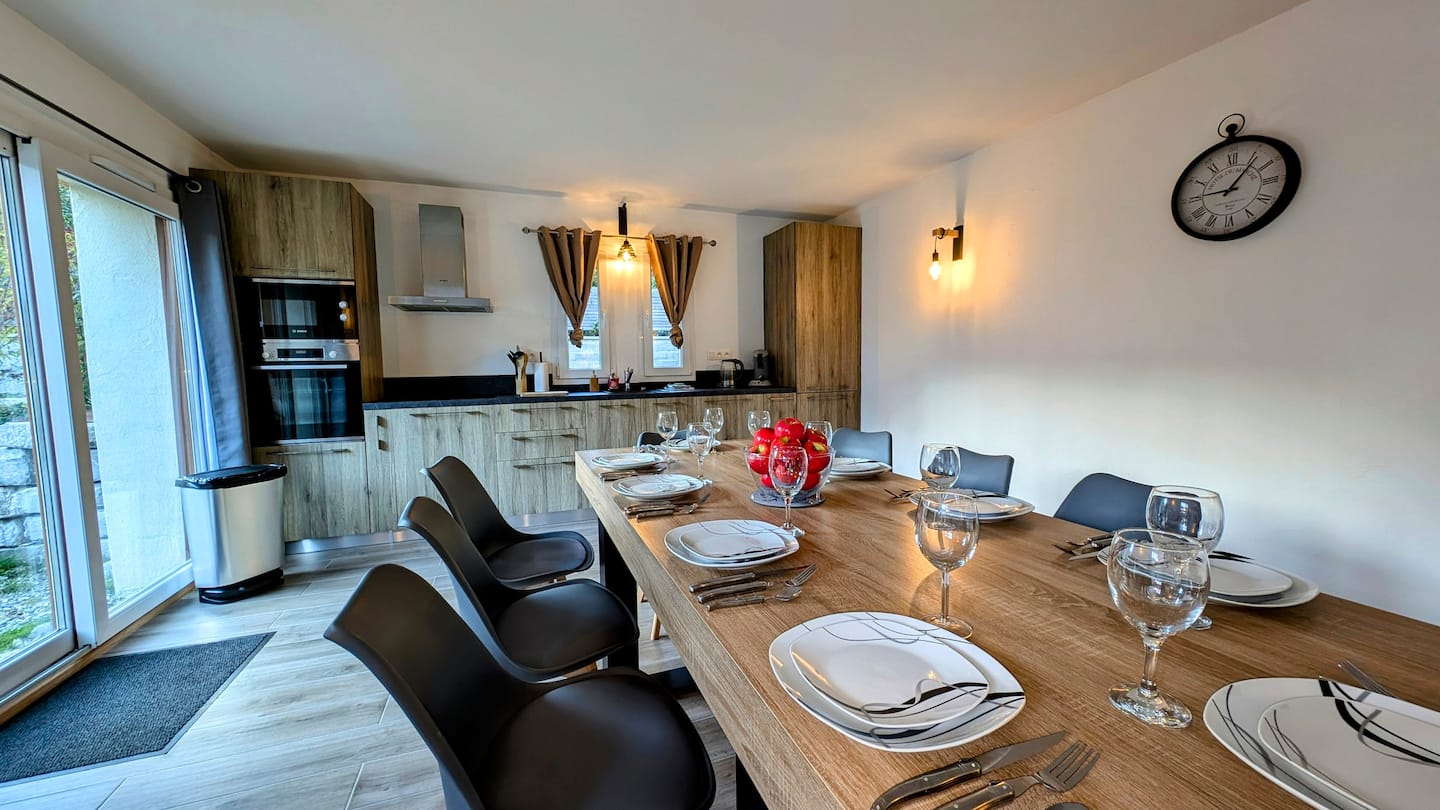 Dining table set for a group beside the open kitchen